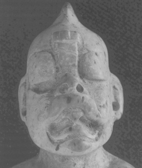 Burial 39 figurine face detail: were-jaguar mouth, trefoil diadem, shark tooth