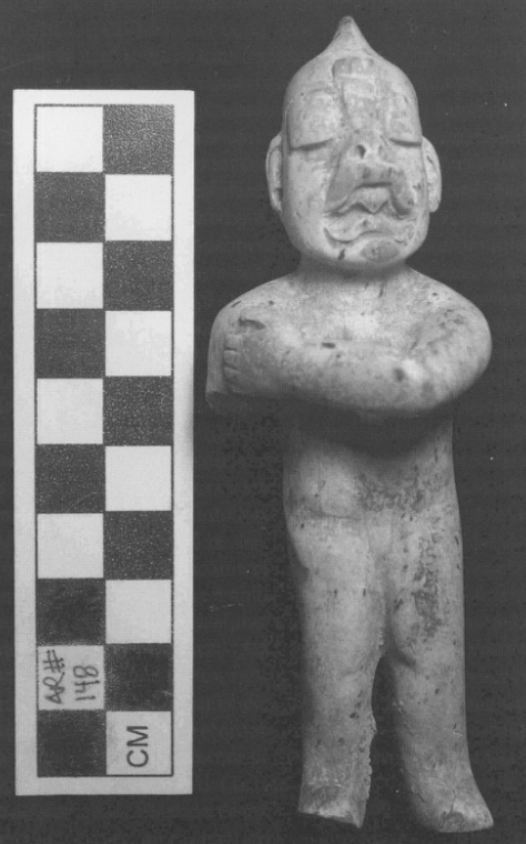 Burial 39 Olmec-style greenstone figurine, frontal view with scale ruler